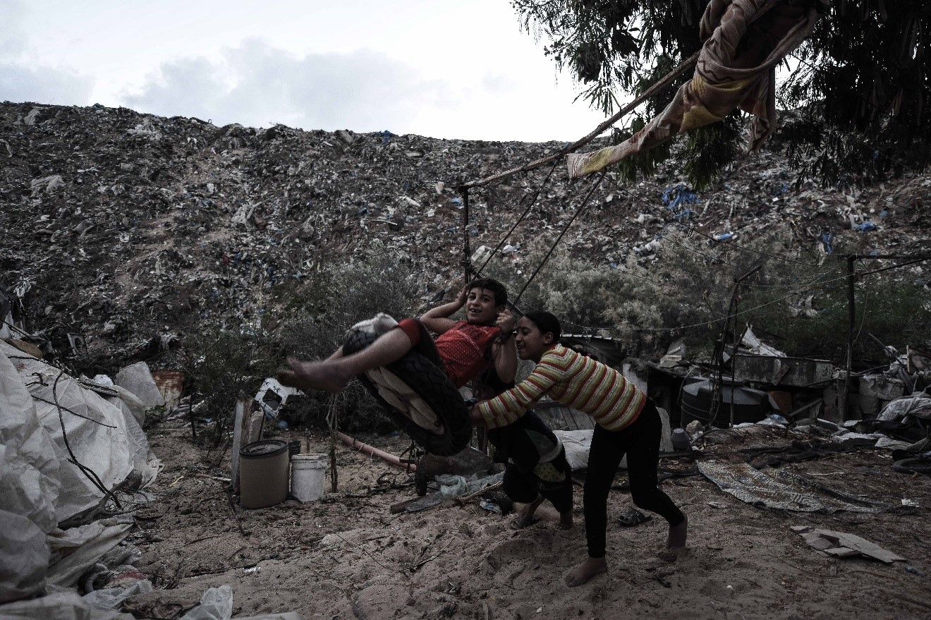 Abfallwirtschaft in Gaza: Gefahren und Herausforderungen Bild: Spielende Kinder nahe ihres Wohnorts in Khan Younis (Gaza). Im Hintergrund ist eine wilde Müllkippe zu sehen.